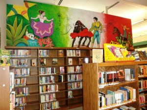 mural of Mexican dancer and bullfighter above bookshelves
